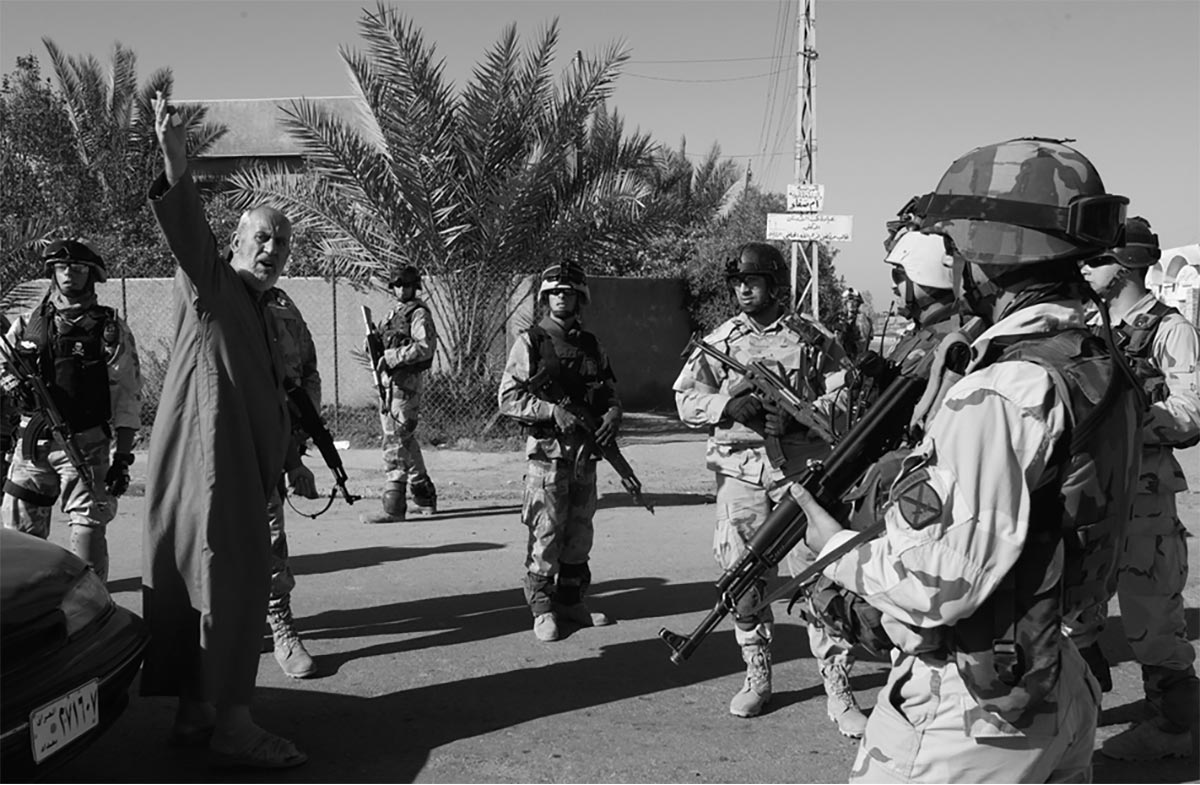 A local resident speaks animatedly after being stopped by Iraqi Army soldiers with the 2d Battalion, 1st Brigade, 10th Mountain Division, in Baghdad.
